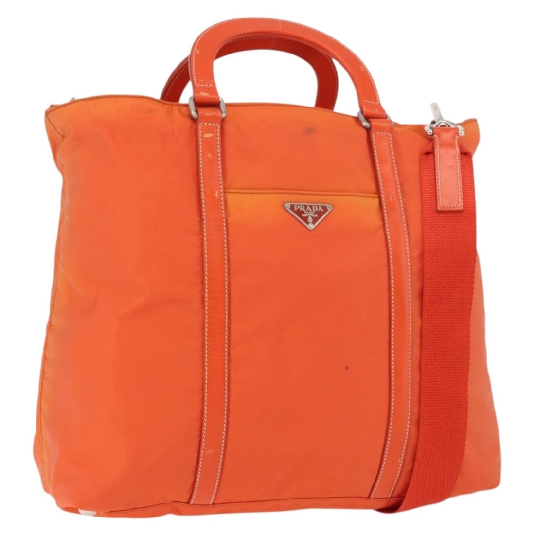 Prada nylon orange silver shoulder bag with strap Italy: Prada nylon orange silver shoulder bag with strap Italy This PRADA handbag is crafted from durable nylon in a striking orange and silver color combination. Designed for versatility, it can be carried 