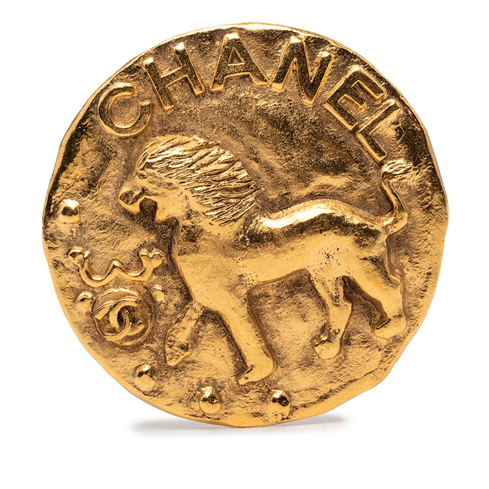 Chanel Lion Medallion Brooch with CC Logo Gold Plated Metal: Chanel Lion Medallion Brooch with CC Logo Gold Plated Metal This Chanel brooch features a round design with a lion motif and is crafted from gold-plated metal. It is equipped with a back pin closure. 