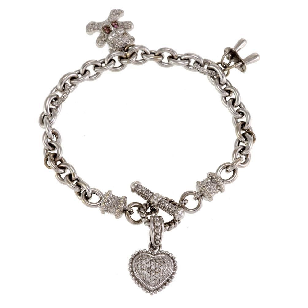 14k White Gold Diamond Charm Bracelet with Bear and Pacifiers: 14k White Gold Diamond Charm Bracelet with Bear and Pacifiers This charming bracelet features a delightful design crafted from 14k white gold. The bracelet showcases an oval link chain adorned with a 