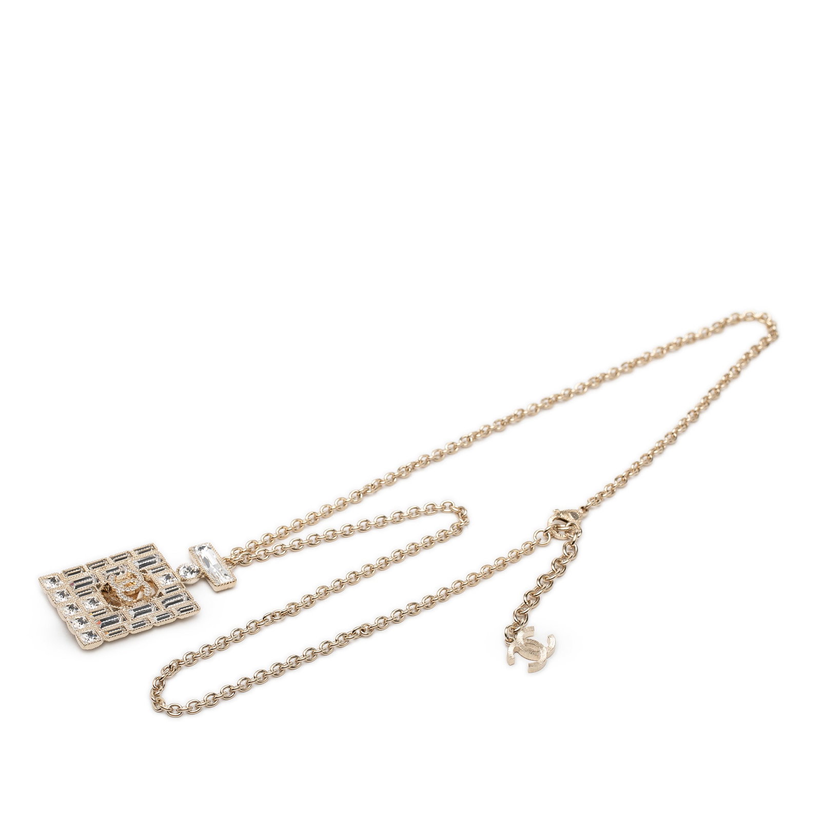 Chanel CC perfume bottle pendant necklace gold tone strass: Chanel CC perfume bottle pendant necklace gold tone strass Chanel costume necklace featuring a gold-tone metal body and a pendant with strass embellishments. It has a lobster clasp closure and was mad