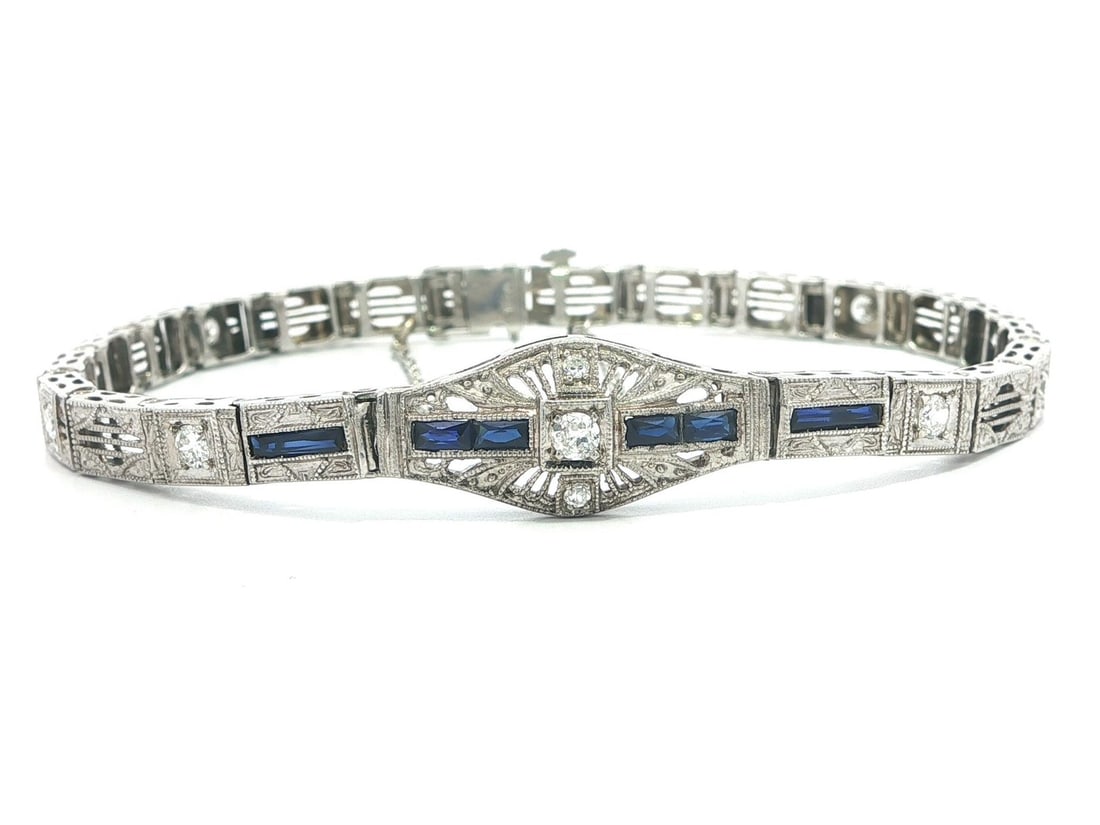 Art Deco Filigree Bracelet in 18k Gold Platinum with Diamond and Sapphire Accents: Art Deco Filigree Bracelet in 18k Gold Platinum with Diamond and Sapphire Accents This Art Deco bracelet features detailed filigree links crafted from solid 18k white gold with a platinum top. The cen
