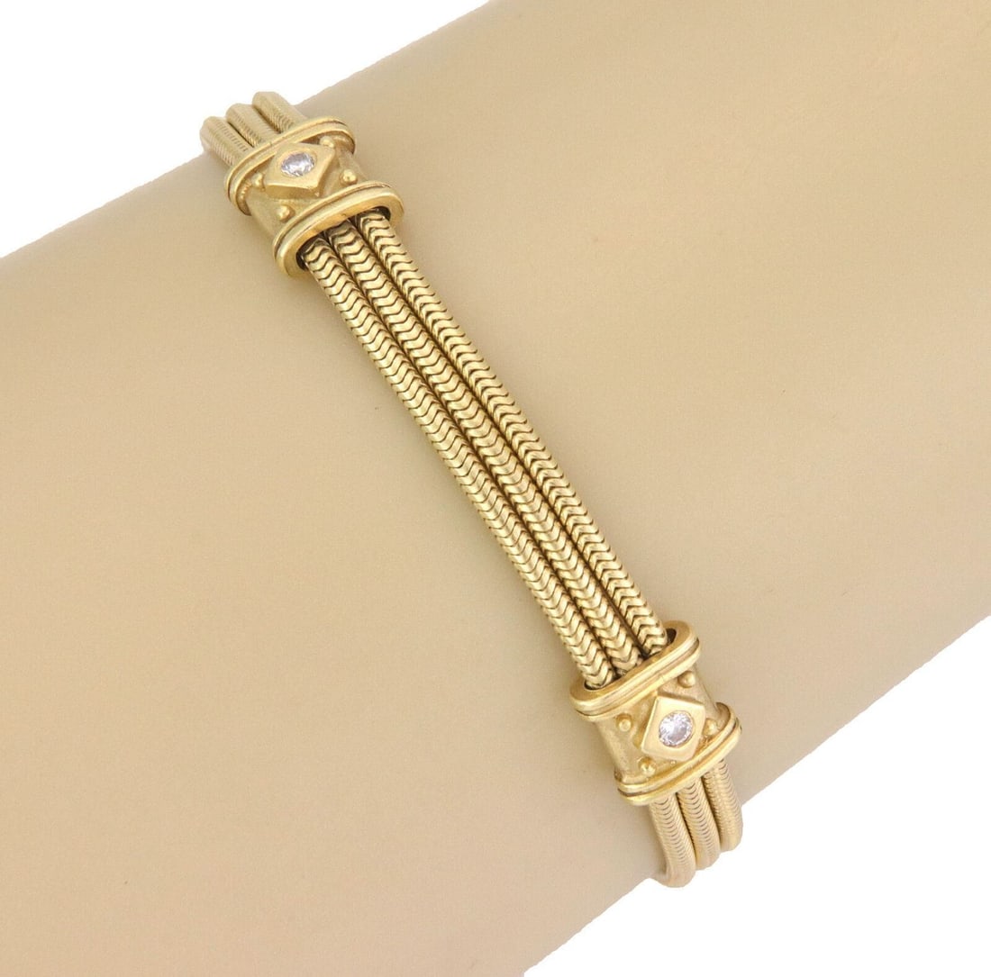 18k Yellow Gold Snake Motif Bracelet with Diamonds by SeidenGang: 18k Yellow Gold Snake Motif Bracelet with Diamonds by SeidenGang A bold and sophisticated SeidenGang snake motif bracelet crafted in 18k yellow gold with natural diamond accents. The sculptural design