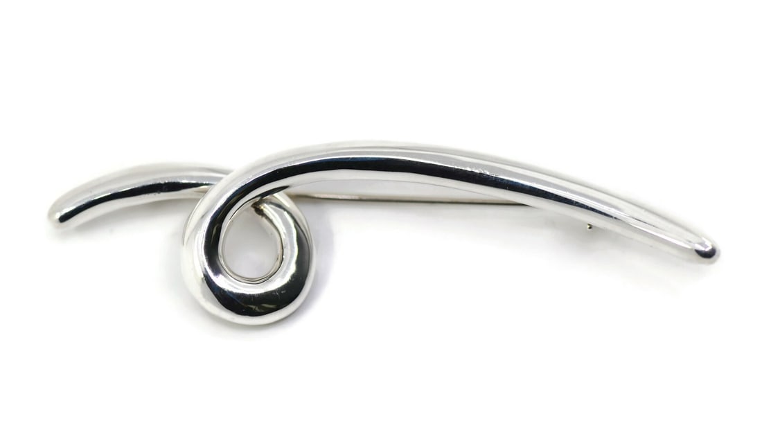 Angela Cummings Sterling Silver Brooch 64mm Authentic Design: Angela Cummings Sterling Silver Brooch 64mm Authentic Design This stunning brooch by Angela Cummings is crafted from sterling silver, showcasing a sleek and elegant design. Measuring 64mm x 17mm and w