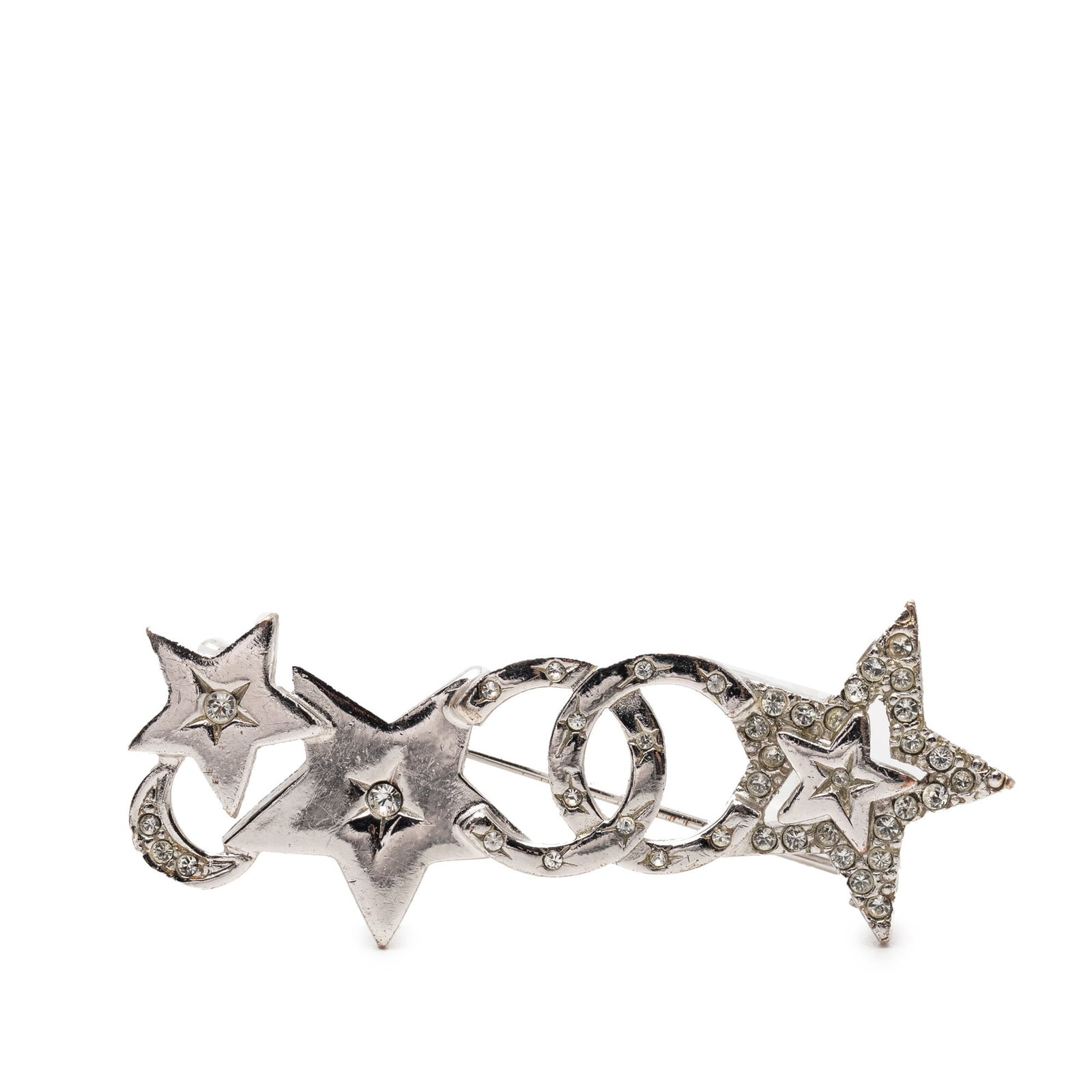 Chanel silver tone star moon crystal brooch: Chanel silver tone star moon crystal brooch This Chanel brooch showcases a silver-tone metal construction adorned with rhinestones in star and moon motifs. It is designed with a back pin closure for s