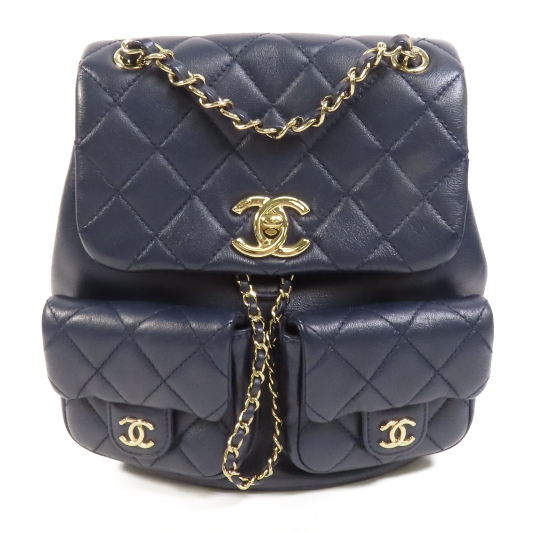 CHANEL Duma AS3860 navy calfskin backpack with gold tone hardware: CHANEL Duma AS3860 navy calfskin backpack with gold tone hardware A CHANEL Duma Chain Backpack in navy blue calfskin leather with CC hardware and a chain strap. The bag features a turn-lock closure, t