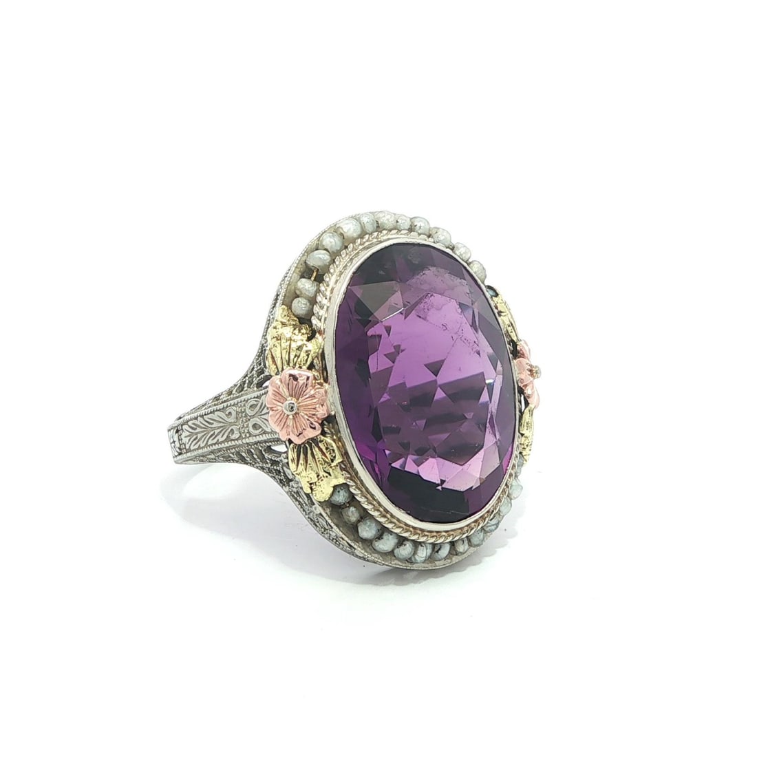 Art Deco 14k Tri Color Gold Filigree Ring with Amethyst and Seed Pearls: Art Deco 14k Tri Color Gold Filigree Ring with Amethyst and Seed Pearls This antique Art Deco cocktail ring features a striking oval brilliant cut natural amethyst in a rich purple hue, bezel set at t