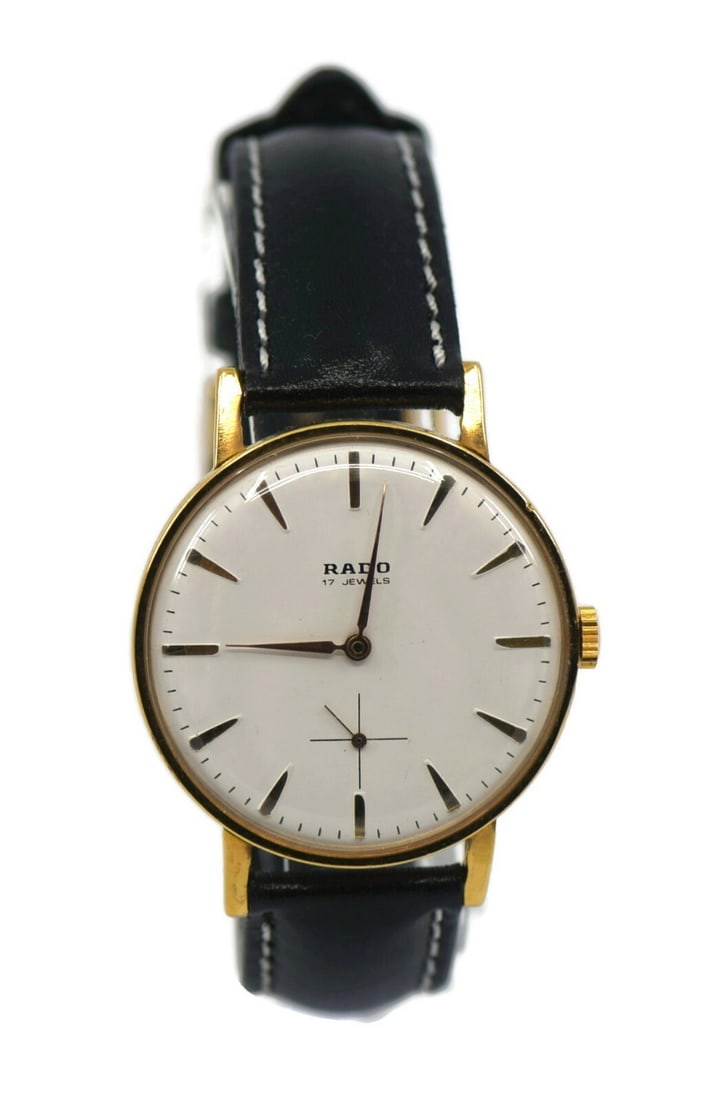 Rado De Luxe Two Tone Mechanical Watch Gold Plated 36mm: Rado De Luxe Two Tone Mechanical Watch Gold Plated 36mm This pre-owned Rado De Luxe Two Tone Wristwatch features a sophisticated design with a striking white dial and a stylish black leather band. The