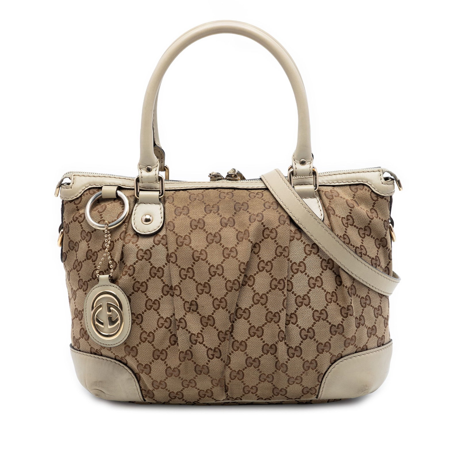 Gucci Sukey Satchel in Beige GG Canvas with Leather Trim: Gucci Sukey Satchel in Beige GG Canvas with Leather Trim Gucci GG Canvas Sukey Satchel crafted with a canvas body and leather trim. This satchel features rolled leather handles, a detachable flat leat