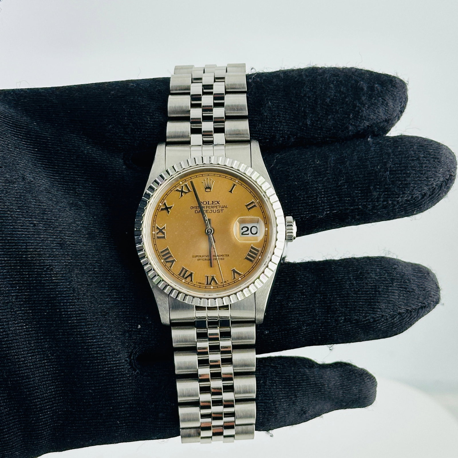 Datejust 16220 Engine Turned Bezel Rolex Jubilee Bracelet Salmon Roman Dial: Datejust 16220 Engine Turned Bezel Rolex Jubilee Bracelet Salmon Roman Dial This is a men's Rolex Datejust wristwatch featuring an aftermarket blue diamond dial. The watch comes with an engine turned 
