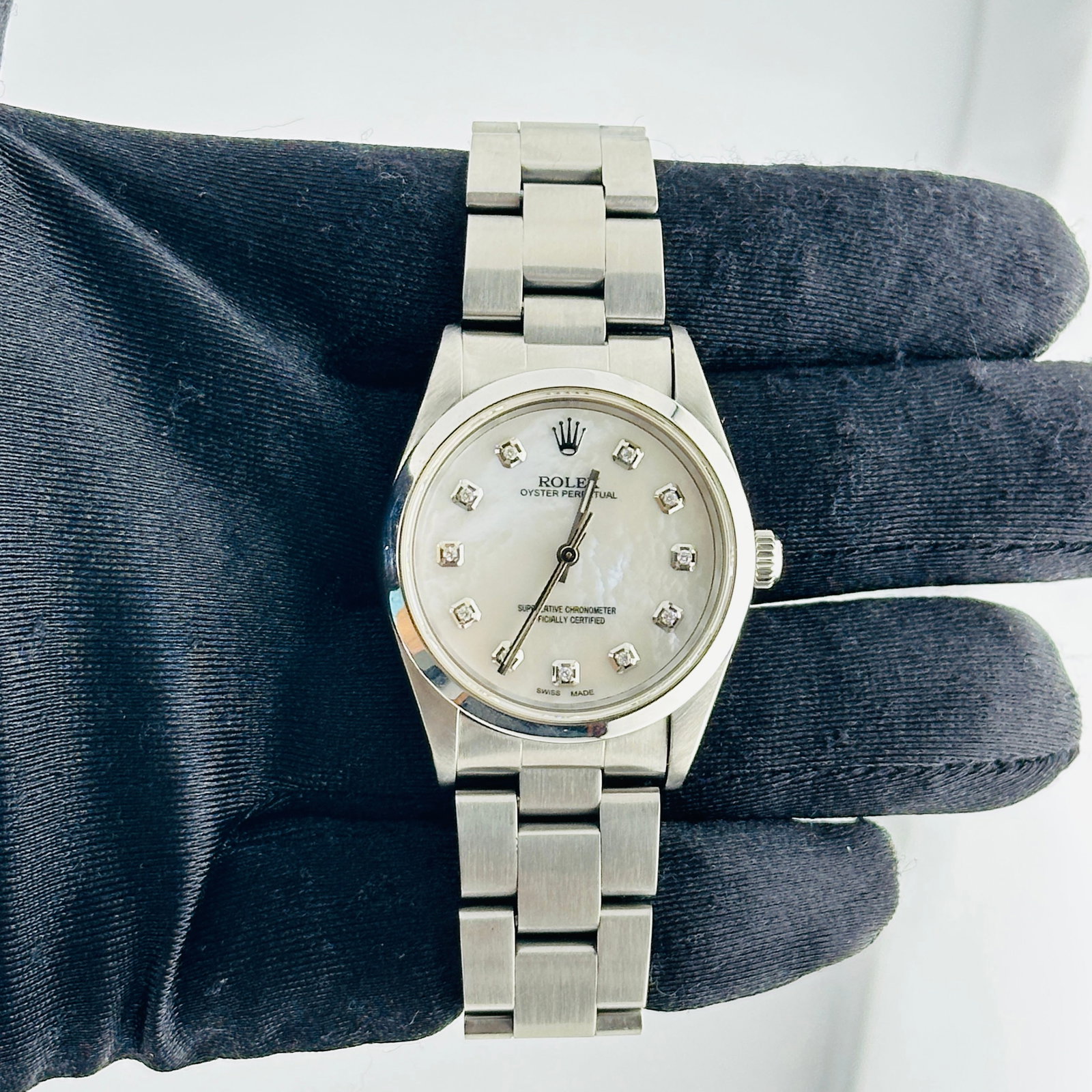 Rolex Air-King 14000 Oyster Bracelet White MOP Diamond Dial: Rolex Air-King 14000 Oyster Bracelet White MOP Diamond Dial This Rolex Air-King features a silver dial with a distinctive mark between the 1 and 3 positions, set within a smooth bezel. The watch is fi