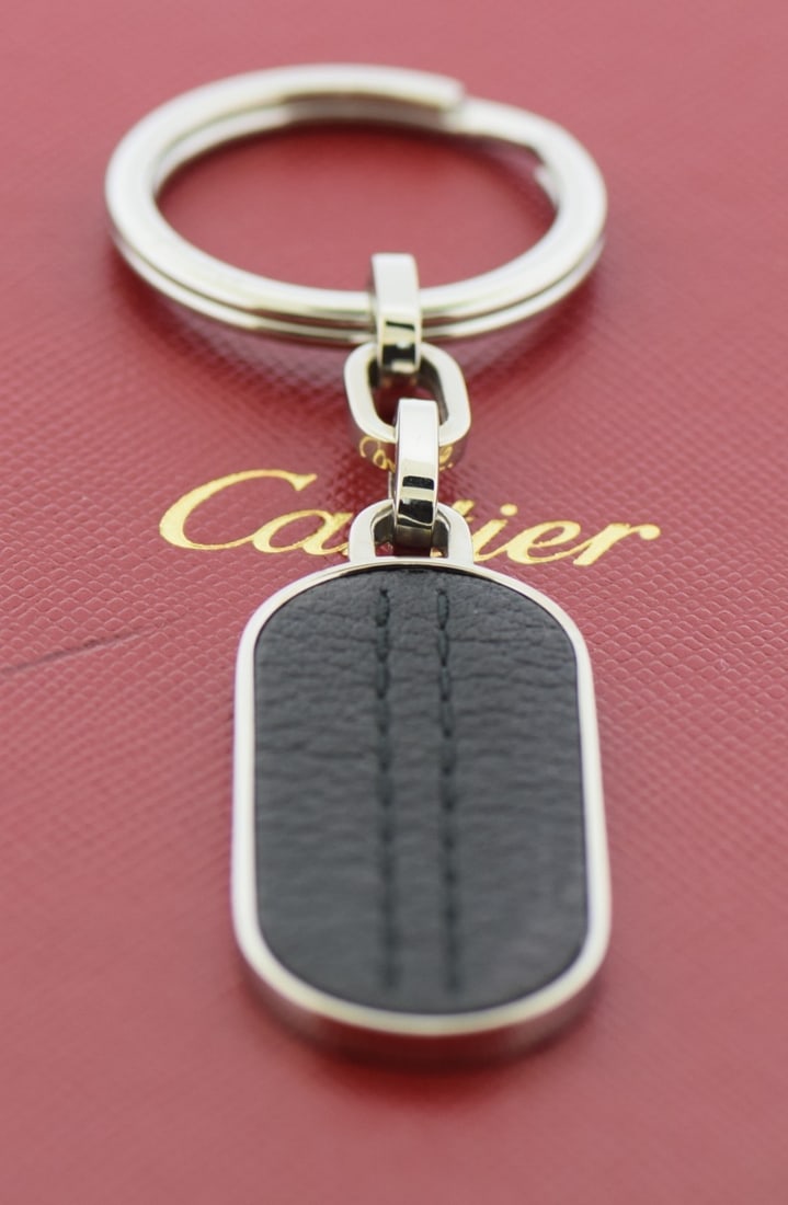 Silver Stainless Steel 41mm Unisex Key Ring by Cartier with Box: Silver Stainless Steel 41mm Unisex Key Ring by Cartier with Box This Cartier key ring is crafted from stainless steel in a sleek silver tone. Designed for unisex use, it offers both durability and sty