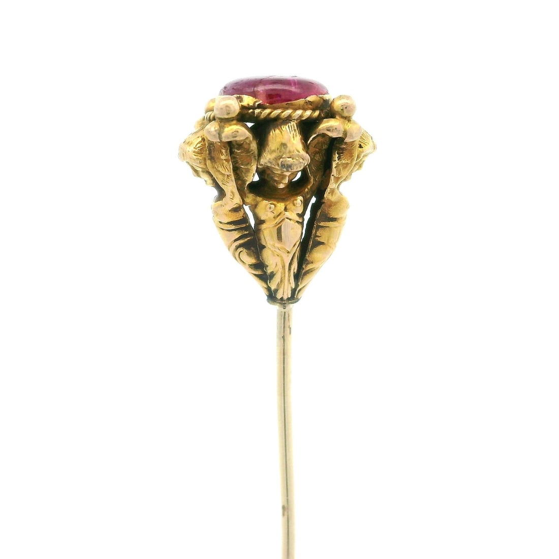 Antique Yellow Gold Cherub Angels Ruby Cabochon Hat Pin: Antique Yellow Gold Cherub Angels Ruby Cabochon Hat Pin This exquisite antique hat pin features a solid yellow gold design adorned with a captivating round cabochon ruby. The cherub angels elegantly h