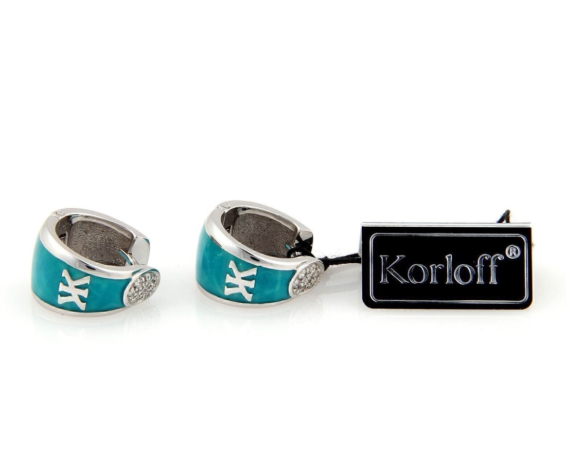 Korloff 18k White Gold Huggie Earrings with Diamond and Enamel: Korloff 18k White Gold Huggie Earrings with Diamond and Enamel These Korloff huggie earrings are crafted in 18k white gold and accented with diamond and enamel detailing. They feature a bold curved si