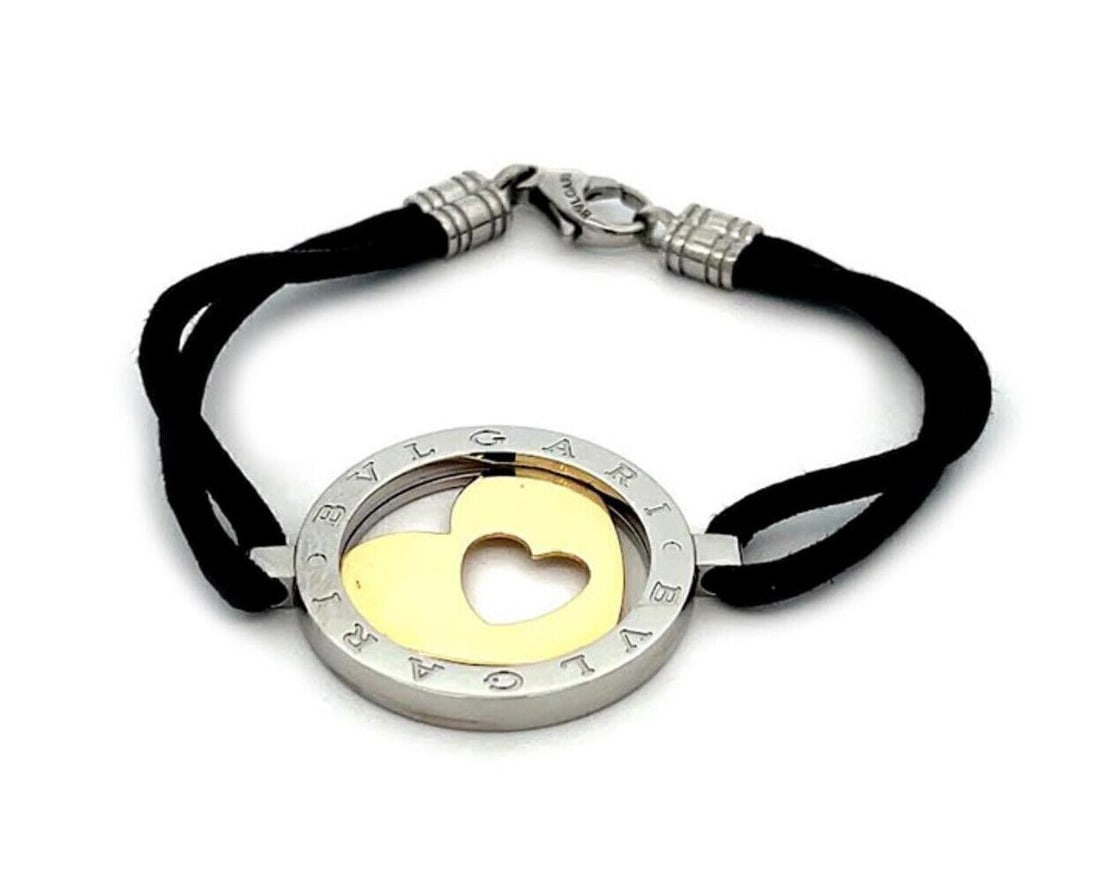 Bvlgari Tondo Heart Circle Cord Bracelet 18k Gold Steel: Bvlgari Tondo Heart Circle Cord Bracelet 18k Gold Steel This pre-owned Bvlgari Tondo Heart Circle cord bracelet is crafted in 18k yellow gold and stainless steel, with a black cord and a round heart m