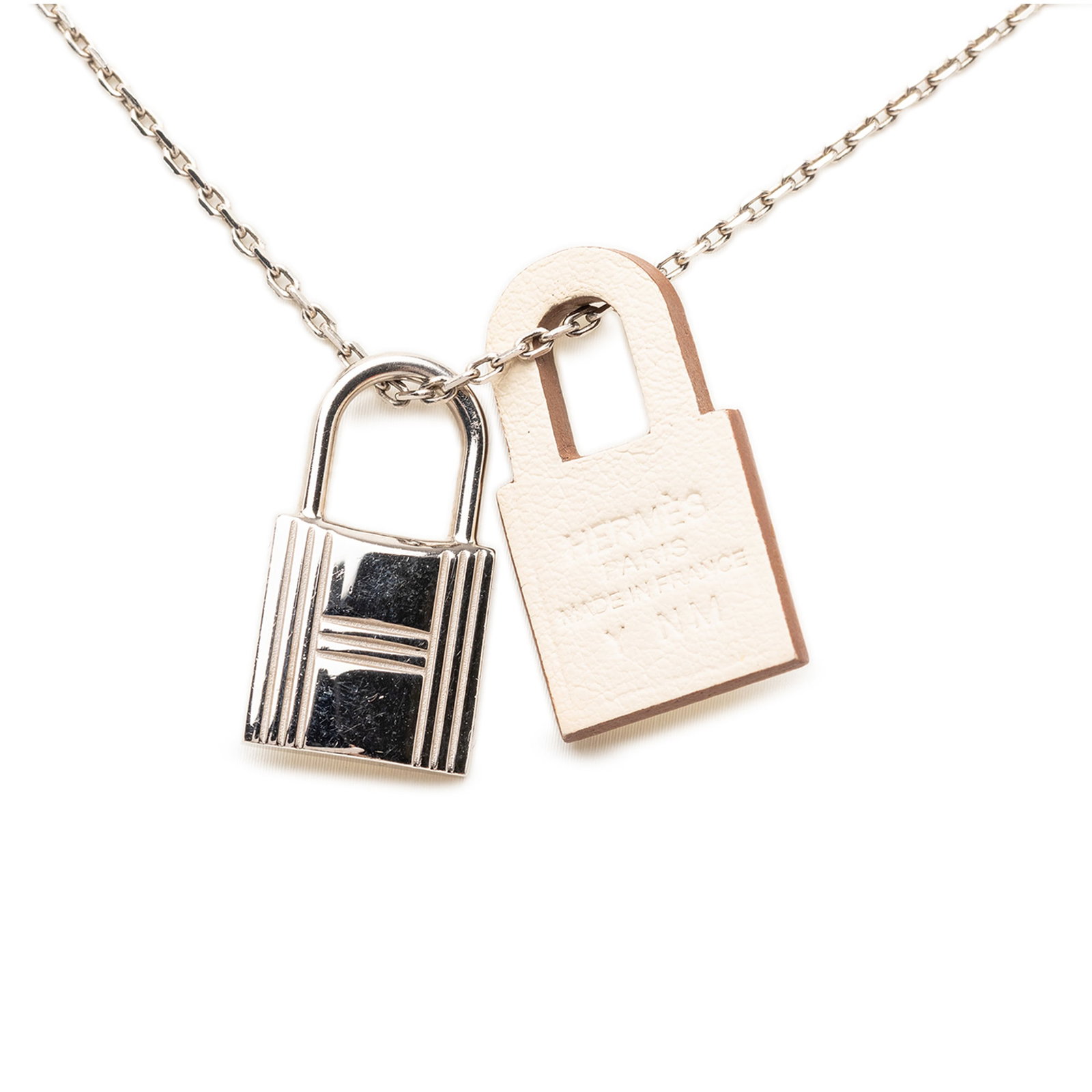 Hermes O Kelly Pendant Necklace Palladium Plated Swift Leather: Hermes O Kelly Pendant Necklace Palladium Plated Swift Leather Hermes O Kelly pendant necklace featuring a palladium-plated design with a padlock pendant accented by Swift leather. Finished with a lob