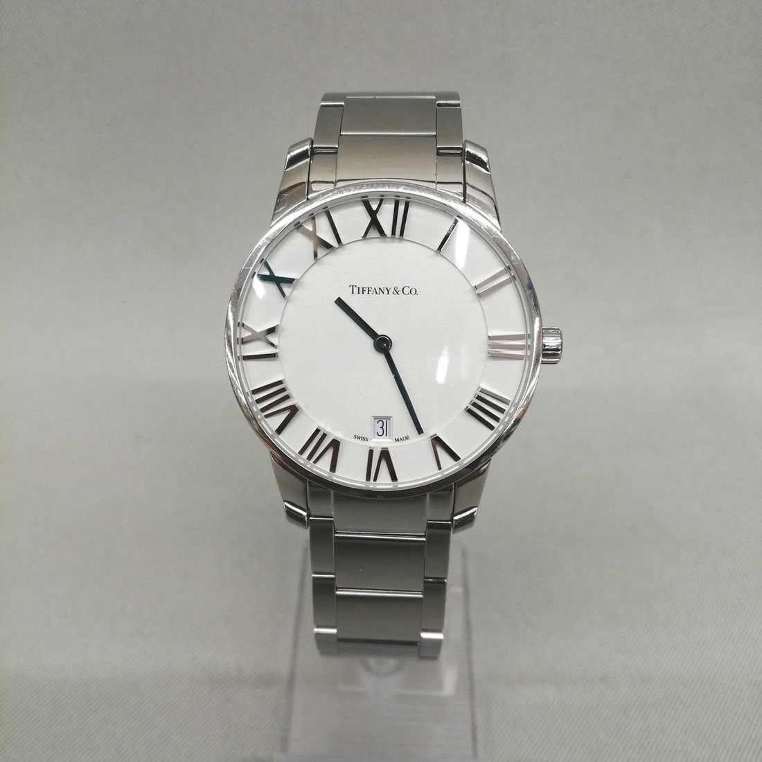 Mens stainless steel quartz wristwatch Tiffany Co Atlas model 34875979: Mens stainless steel quartz wristwatch Tiffany Co Atlas model 34875979 Men's pre-owned wristwatch from the Atlas line with a quartz analog movement. It features a stainless steel case and stainless st