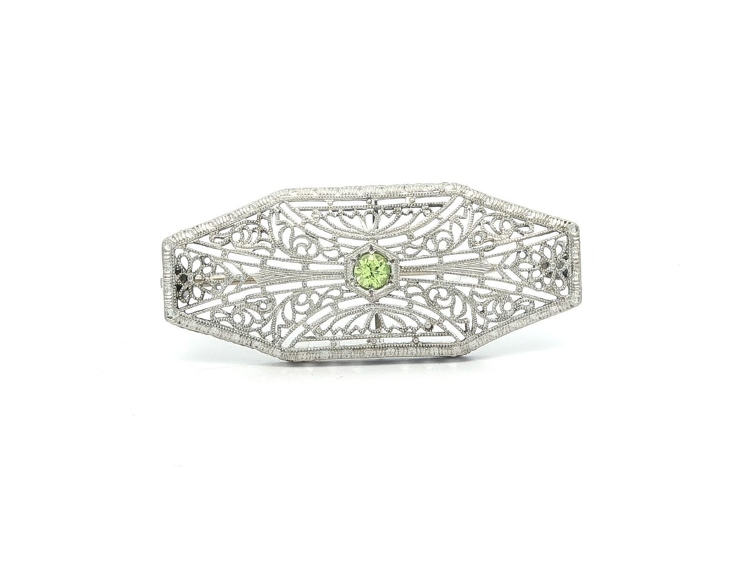 Antique Art Deco 14k White Gold Peridot Filigree Brooch: Antique Art Deco 14k White Gold Peridot Filigree Brooch This exquisite Antique Art Deco brooch features a stunning 2.6mm natural genuine peridot, elegantly crafted in a round brilliant cut and pave se