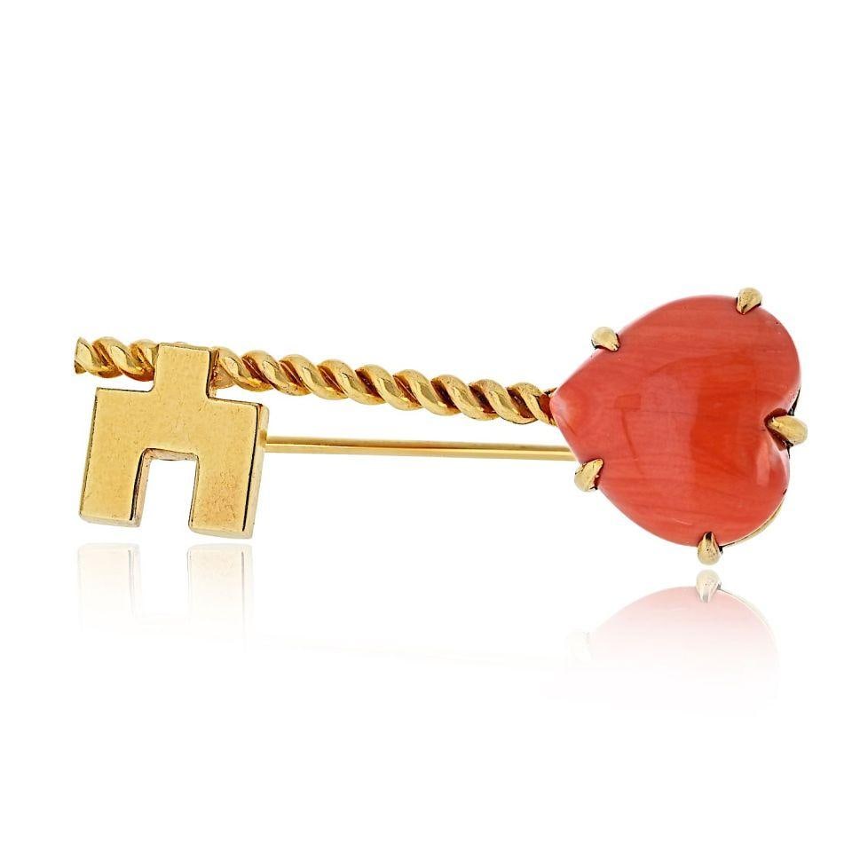 18K Yellow Gold Brooch with Heart Coral Motif by Van Cleef & Arpels: 18K Yellow Gold Brooch with Heart Coral Motif by Van Cleef & Arpels This Van Cleef & Arpels key brooch is crafted in 18K yellow gold and features a delicate design with a heart-shaped natural coral mo