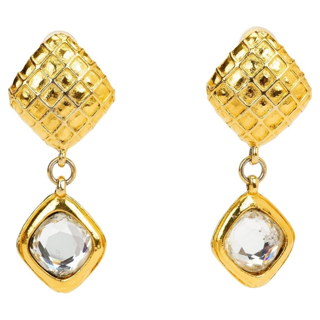Chanel gold plate crystal dangle clip on earrings: Chanel gold plate crystal dangle clip on earrings These vintage Chanel dangle earrings from the 1970s feature a gold-plated metal construction with a distinctive quilted upper section and a dangling s