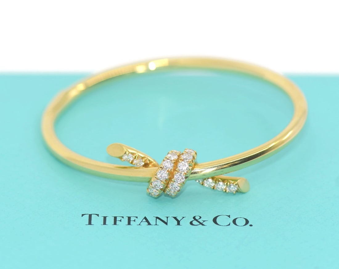 Tiffany & Co XS Knot Diamond 18K Yellow Gold Bangle Bracelet: Tiffany & Co XS Knot Diamond 18K Yellow Gold Bangle Bracelet A pre-owned Tiffany & Co knot diamond bracelet in 18K yellow gold. The design features a knot shape with round natural diamonds and a bangl