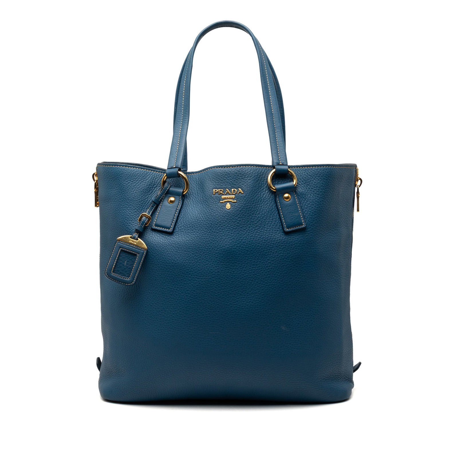 Prada blue leather side zip shopper tote: Prada blue leather side zip shopper tote This Prada Vitello Daino Side Zip Shopper Tote is crafted from blue leather and features side zip expansions, flat leather straps, and an open top with a magne