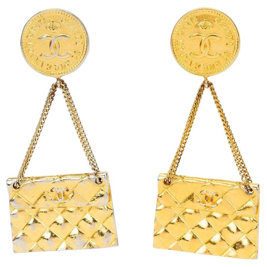 Chanel Vintage Gold Plate Coin Dangle Clip On Earrings: Chanel Vintage Gold Plate Coin Dangle Clip On Earrings These vintage Chanel clip-on earrings from 1982 feature a gold-plated metal design. The earrings showcase a coin medallion with the iconic interl
