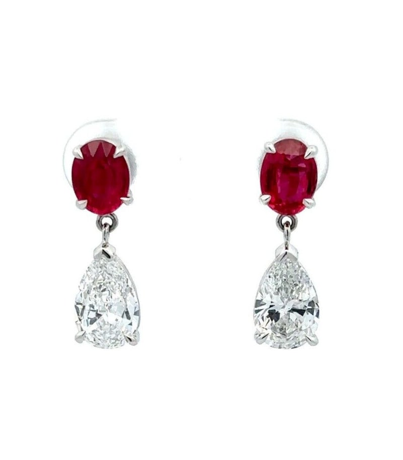 GIA Certified Platinum Ruby Diamond Drop Earrings 4.22ctw: GIA Certified Platinum Ruby Diamond Drop Earrings 4.22ctw These platinum drop dangle earrings showcase two vivid red, natural oval-cut rubies sourced from Mozambique, paired with two pear brilliant-cu