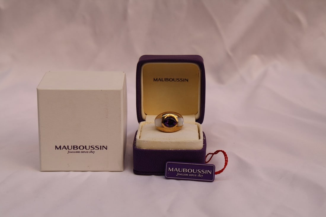 Mauboussin 18K Gold Amethyst Mother of Pearl Ring Size 5: Mauboussin 18K Gold Amethyst Mother of Pearl Ring Size 5 Introducing a stunning Mauboussin ring, crafted from luxurious 18K yellow gold. This exquisite piece features a captivating amethyst stone and 