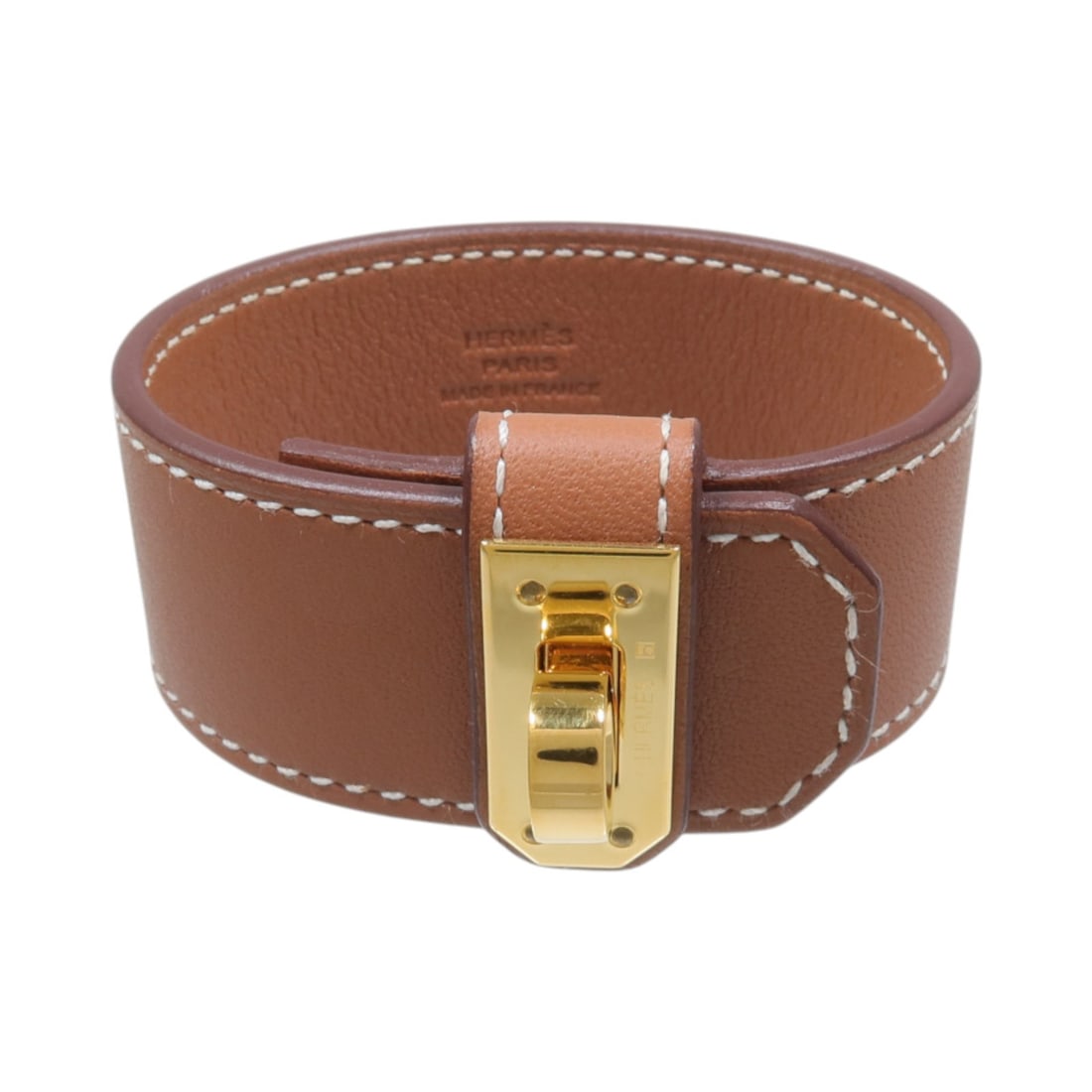 Hermes Kelly Twist Bracelet Gold Swift Leather Calfskin: Hermes Kelly Twist Bracelet Gold Swift Leather Calfskin A Hermes Kelly Twist bracelet in Swift leather and gold-tone metal, presented in a gold and brown colorway. The bracelet includes the original s