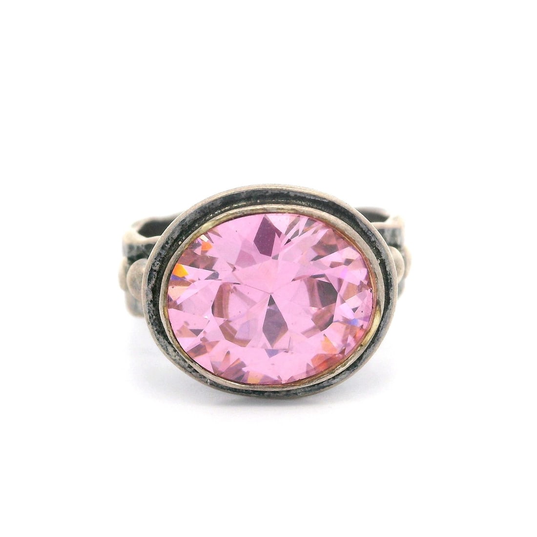 Vintage Sterling Silver Pink Cubic Zirconia Hammered Band Ring: Vintage Sterling Silver Pink Cubic Zirconia Hammered Band Ring This vintage cocktail ring is crafted in high-quality sterling silver and features a stunning pink cubic zirconia stone. The oval brillia
