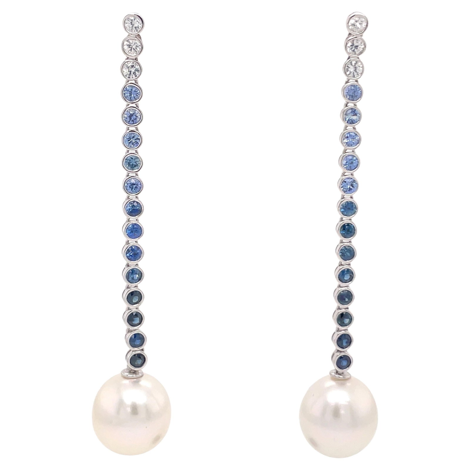 18K White Gold South Sea Pearl Drop Earrings with Ombree Sapphires: 18K White Gold South Sea Pearl Drop Earrings with Ombree Sapphires Elevate your elegance with these stunning 18 Karat White Gold Sapphire Ombree Pearl Drop Earrings. Crafted from high-quality white go