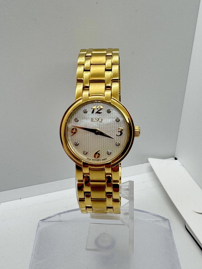 Ladies 26mm ESQ Movado Gold Plated Quartz Watch Mother of Pearl Dial: Ladies 26mm ESQ Movado Gold Plated Quartz Watch Mother of Pearl Dial This ESQ by Movado ladies quartz wristwatch features a 26mm gold-plated stainless steel case with a white mother of pearl dial. The