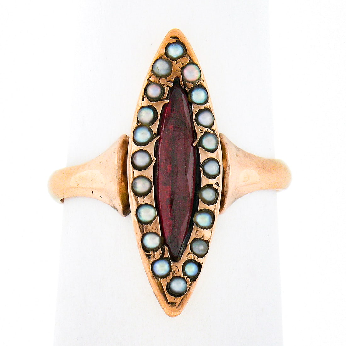 Victorian 10k Gold Marquise Carnelian Seed Pearl Halo Ring: Victorian 10k Gold Marquise Carnelian Seed Pearl Halo Ring This exquisite antique ring, crafted from solid 10k rosy yellow gold, showcases a stunning marquise cut carnelian at its center. The natural 