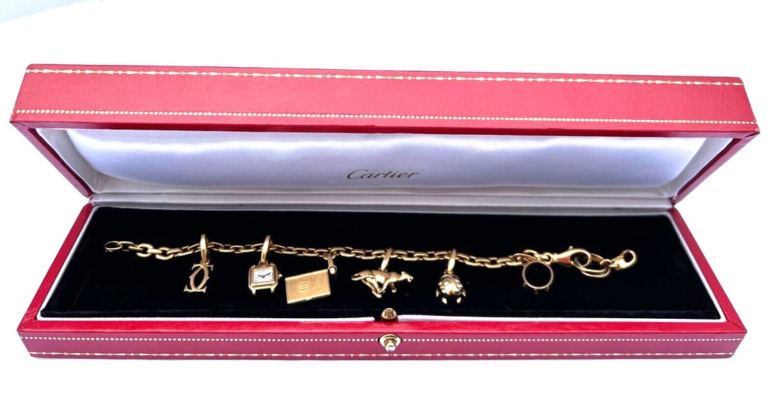 Cartier 18K Yellow Gold Charm Bracelet with 7 Signed Charms and Box: Cartier 18K Yellow Gold Charm Bracelet with 7 Signed Charms and Box Discover the elegance of this original French Cartier charm bracelet, crafted from luxurious 18k yellow gold. This exquisite piece f