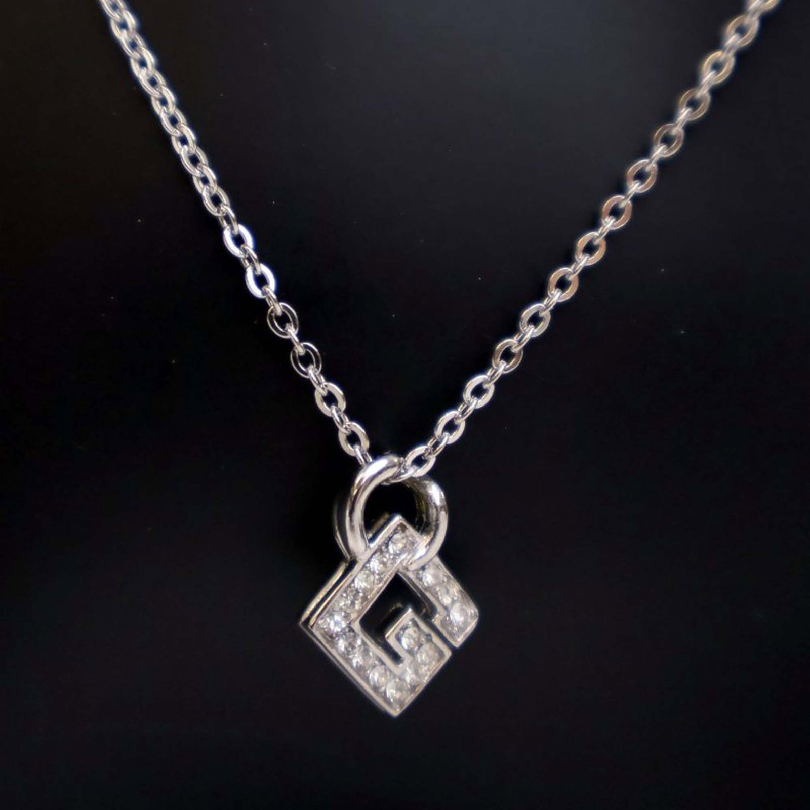 Givenchy G Logo Rhinestone Pendant Necklace Silver Plated: Givenchy G Logo Rhinestone Pendant Necklace Silver Plated This Givenchy necklace showcases a silver tone G logo pendant adorned with rhinestone accents, suspended from a metal chain and secured with a