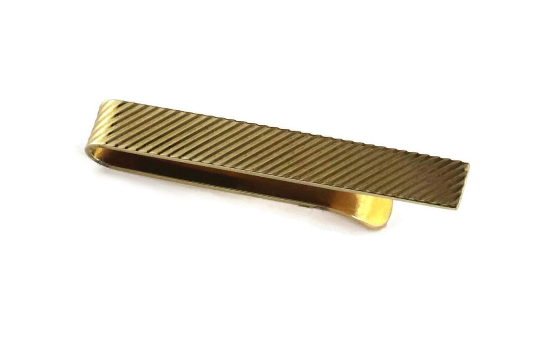 Tiffany & Co. Fluted Slanted Tie Clip in 14k Yellow Gold: Tiffany & Co. Fluted Slanted Tie Clip in 14k Yellow Gold An authentic vintage tie clip crafted in 14k yellow gold with a fluted slanted design and polished finish. It measures approximately 1.67 inche