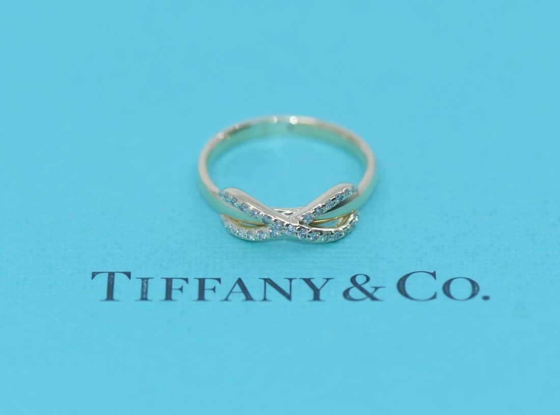 Infinity Motif Diamond Ring in 18K Yellow Gold Size 6 by Tiffany & Co: Infinity Motif Diamond Ring in 18K Yellow Gold Size 6 by Tiffany & Co This pre-owned Tiffany & Co. Infinity ring is crafted from 18K yellow gold and features diamond accents. The ring is a size 6 and 