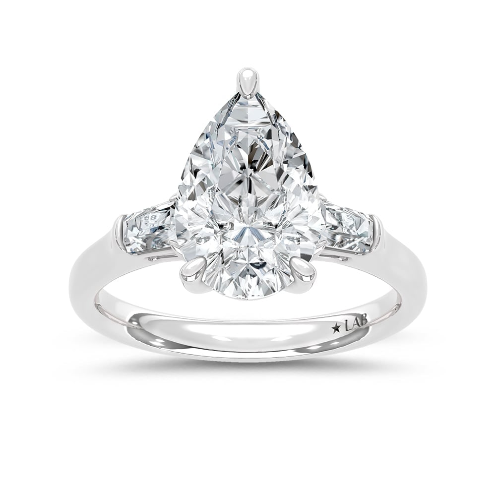 14K White Gold Lab Grown Diamond 3 1/5 Ct.Tw. Pear and Tapper Three Stone Engagement Ring: 14K White Gold Lab Grown Diamond 3 1/5 Ct.Tw. Pear and Tapper Three Stone Engagement Ring This stunning three-stone ring features a sparkling 3 CT Pear Center diamond with two shimmering side diamonds