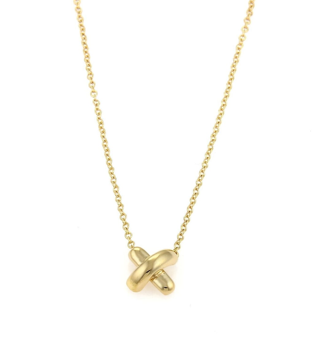 Tiffany & Co. Stitch Crossover Pendant Necklace in 18k Yellow Gold: Tiffany & Co. Stitch Crossover Pendant Necklace in 18k Yellow Gold A pre-owned Tiffany & Co. stitch crossover pendant necklace crafted in 18k yellow gold. It features a delicate polished crossover mot