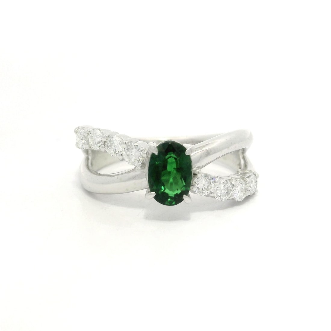 Platinum 1.44ctw Green Tsavorite Diamond Crossover Band Ring: Platinum 1.44ctw Green Tsavorite Diamond Crossover Band Ring This stunning crossover design band ring features a vibrant 1.44ctw of natural gemstones, including a vivid green oval-cut Tsavorite at the