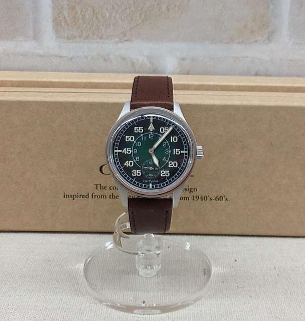 OUTLINE YK20231-60 mens wristwatch military style aftermarket belt: OUTLINE YK20231-60 mens wristwatch military style aftermarket belt Men's pre-owned wristwatch by OUTLINE with a military-type 1940 design. It includes an aftermarket belt and is identified by model nu
