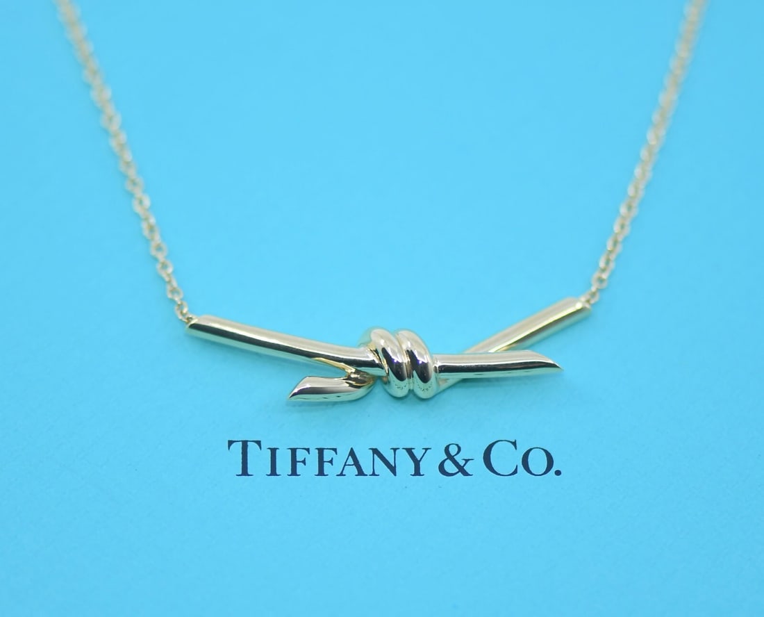 Tiffany & Co Knot Pendant 18K Yellow Gold 17 Inch Necklace: Tiffany & Co Knot Pendant 18K Yellow Gold 17 Inch Necklace This pre-owned Tiffany & Co. necklace features a classic knot pendant crafted from 18K yellow gold. The pendant measures 39mm and is presente