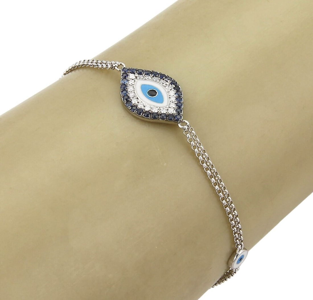 18k White Gold Evil Eye Bracelet with Diamond Sapphire Enamel: 18k White Gold Evil Eye Bracelet with Diamond Sapphire Enamel This vintage estate evil eye double chain bracelet is crafted in 18k white gold and features an eye centerpiece accented with diamonds, sa