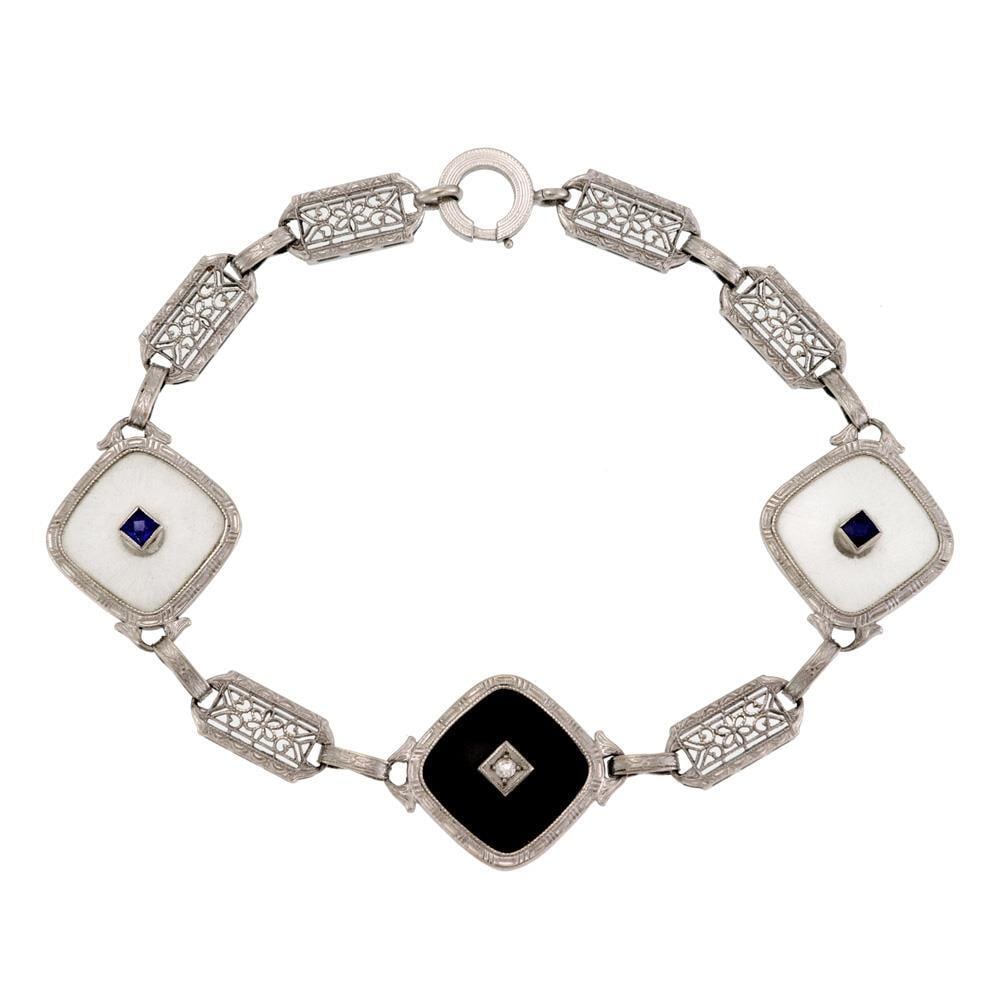 Art Deco 14k Gold Filigree Bracelet with Onyx Diamond and Sapphire: Art Deco 14k Gold Filigree Bracelet with Onyx Diamond and Sapphire This exquisite Art Deco bracelet is a stunning example of vintage craftsmanship, made from 14k white gold. It features three trillion