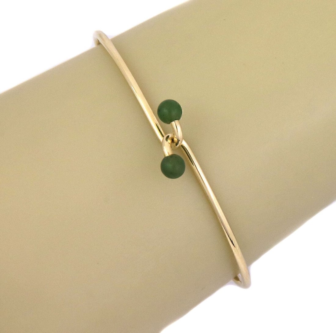 Tiffany & Co. Wire Hook Bangle Bracelet in 14k Yellow Gold with Jade: Tiffany & Co. Wire Hook Bangle Bracelet in 14k Yellow Gold with Jade A pre-owned Tiffany & Co. jade wire hook bangle bracelet crafted in 14k yellow gold. It features a minimalist open wire hook design