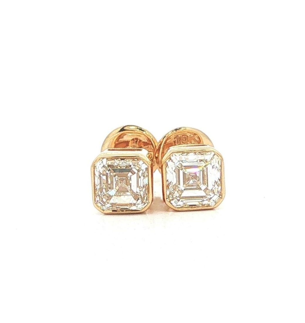 GIA Asscher Cut Diamond Bezel Stud Earrings 18k Yellow Gold: GIA Asscher Cut Diamond Bezel Stud Earrings 18k Yellow Gold These elegant stud earrings feature two natural Asscher cut diamonds with a combined total carat weight of 1.8, each certified by GIA. The d