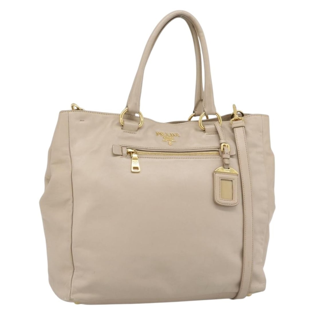 PRADA Beige Leather 2 Way Handbag with Shoulder Strap and Name Tag: PRADA Beige Leather 2 Way Handbag with Shoulder Strap and Name Tag Prada 2-way hand bag in leather with a beige and gold color scheme. Made in Italy, it comes with a name tag and shoulder strap. The b