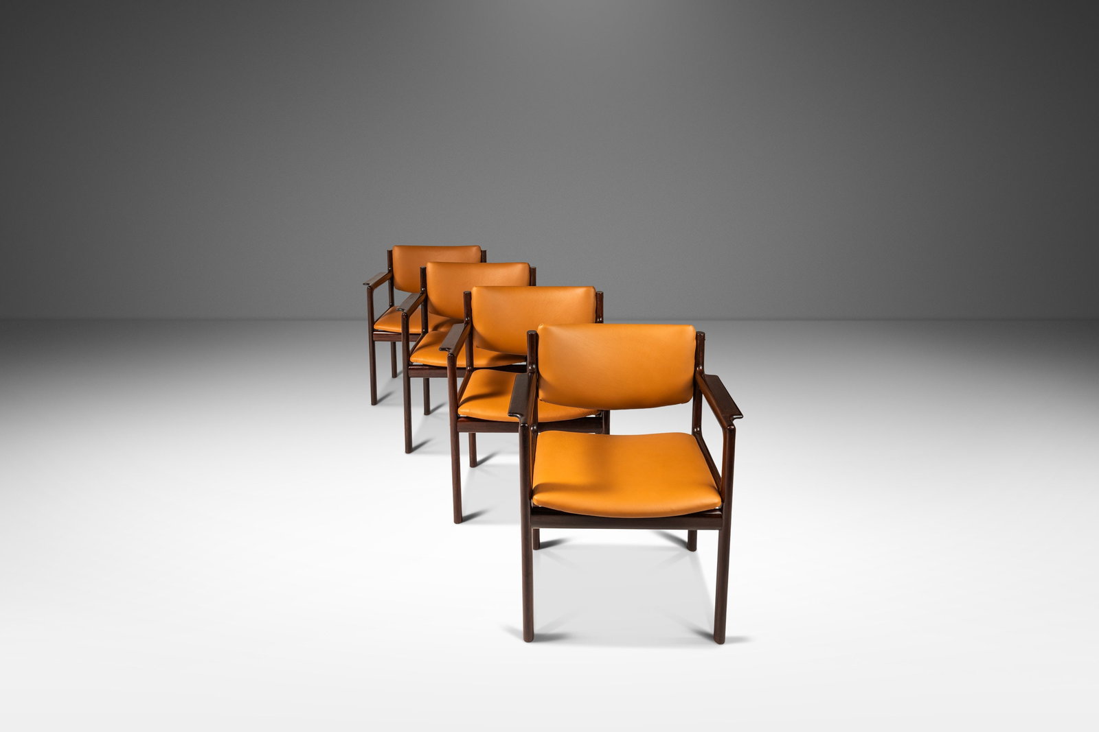 Rare Set of 4 Danish Modern Arm Chairs in Mahogany & Caramel Leather: Rare Set of 4 Danish Modern Arm Chairs in Mahogany & Caramel Leather This exquisite set of four Danish Modern arm chairs showcases the finest craftsmanship with solid mahogany frames and luxurious car