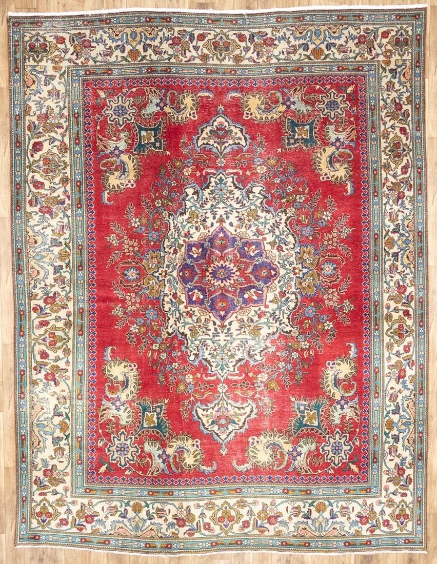 10x13 Ft Hand-Knotted Wool Floral Oriental Area Rug: 10x13 Ft Hand-Knotted Wool Floral Oriental Area Rug This semi-antique Oriental rug is hand-knotted from wool and features a muted color palette including red, cream, blue, purple, pale pink, and gold.