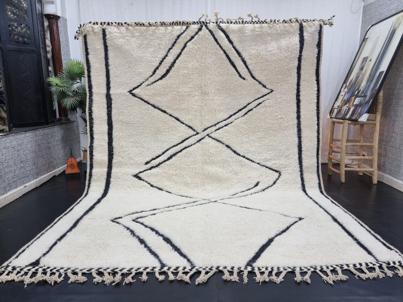 Authentic Moroccan Berber Wool Rug Soft White 9.84 x 6.56 Feet: Authentic Moroccan Berber Wool Rug Soft White 9.84 x 6.56 Feet Discover the exquisite charm of this Authentic Soft White Handmade Moroccan Berber Wool Rug, featuring a striking black engraved pattern.